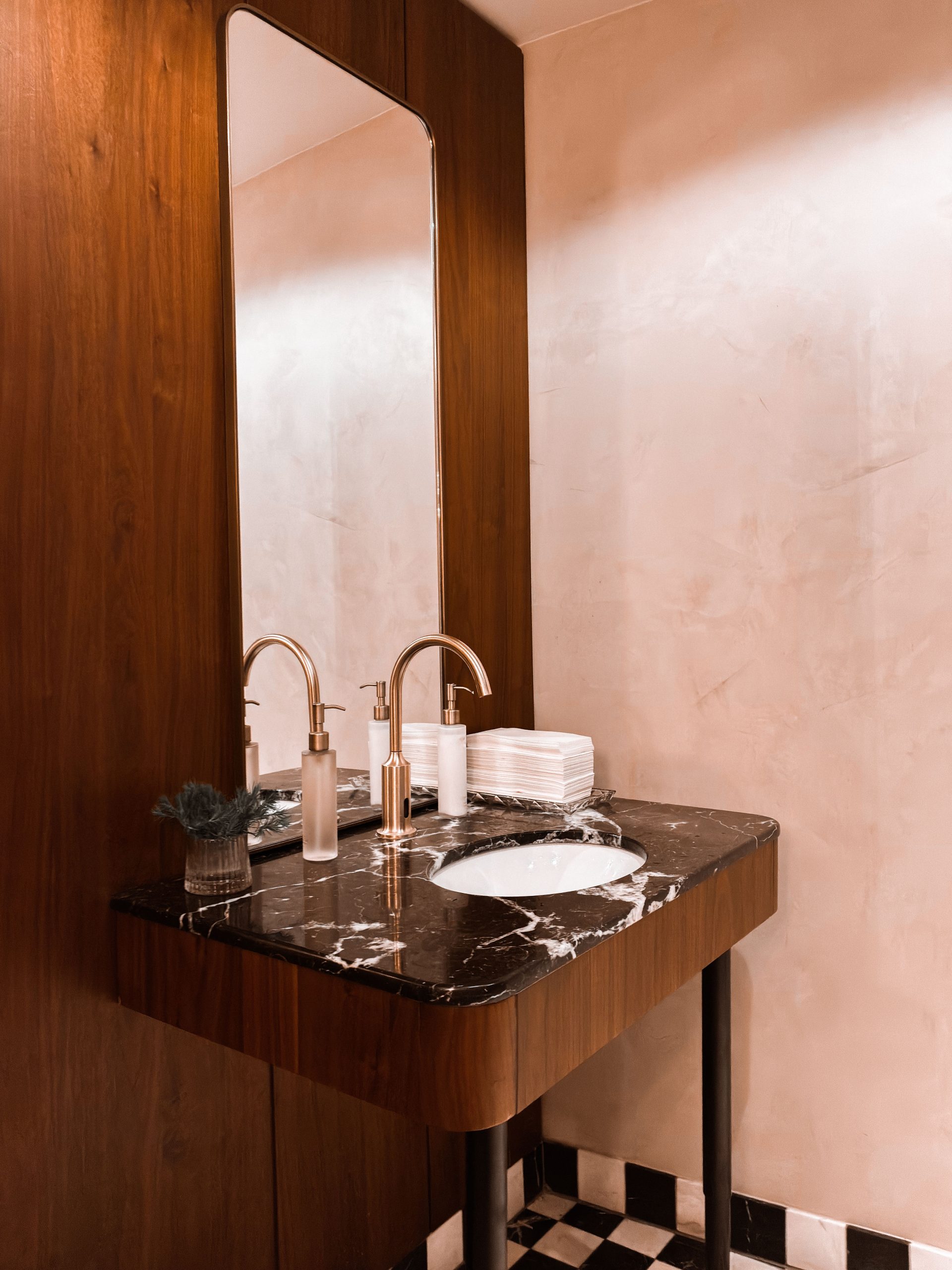 Stylish bathroom featuring a marble sink and wooden vanity. Modern and sophisticated interior design.